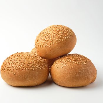 stack of baked whole round bun with sesame seeds made from white wheat flour on a white background